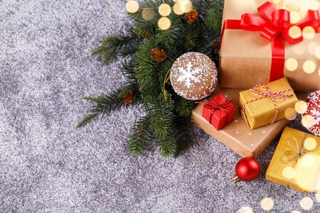 Gift boxes wraped with golden and craft paper red ribbons, Christmas decorations on grey background, copy space flat layの写真素材