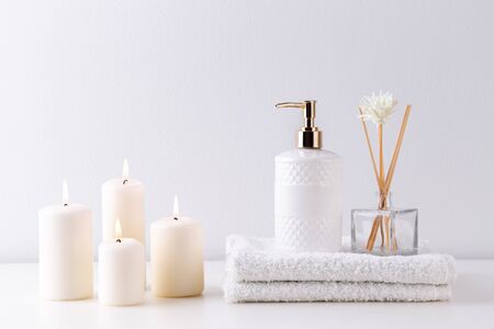 Health care and spa items on white shelf, towels, candles and soapの写真素材