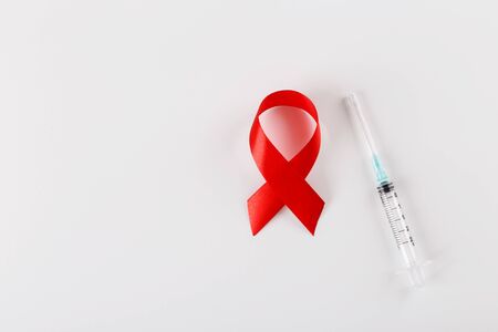 Red ribbon and syringe on white background, world cancer day conceptの写真素材