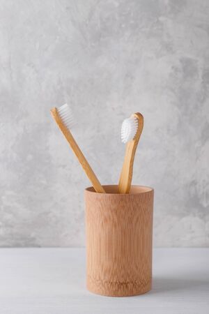 Zero waste bamboo toothbrushes in a wooden container, vertical shotの写真素材