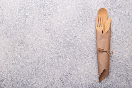 Zero waste bamboo tableware, eco friendly paper napkin and cups, wooden cutlery on natural stone background. Top view copy spaceの写真素材