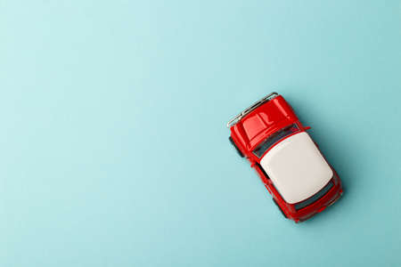 Red small toy car on blue background, postcard concept, copy spaceの写真素材
