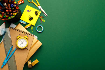 Back to school concept. Colorful stationary school supplies on green background, space or text flat...