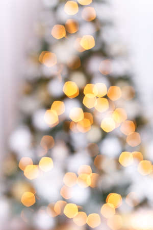 Abstract Christmas background with defocused lights, festive tree with white and gold decorationsの写真素材