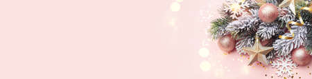 Christmas or new year card template, pine tree branch with modern festive ornaments on pink background banner with copy spaceの写真素材