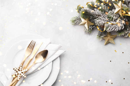 Christmas or new year table setting with golden cutlery on white stone table, card or menu template copy space flat layの写真素材