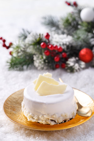 White chocolate Christmas cake on golden plate with festive decorations, horizontalの写真素材