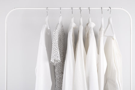 White spring summer female clothes hanging on a rack in a shopの写真素材