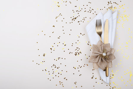 Elegant table setting with golden cutlery on beige table, card or menu template copy space flat layの写真素材