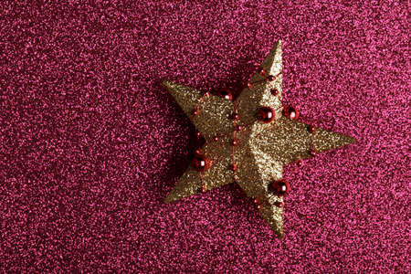Golden Christmas or New year star on red glitter background, vertical greetings card template, winter holidaysの写真素材