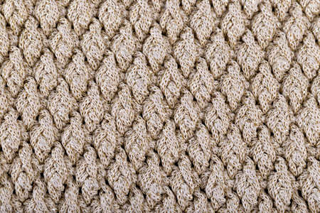 Texture of beige knitted woolen fabric for wallpaper and an abstract background