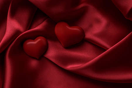 Two red hearts on a silk background, Valentine's day concept.の写真素材