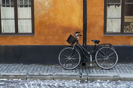 Black bike with a basket on the background of a red wall in Stockholm , Swedenの写真素材