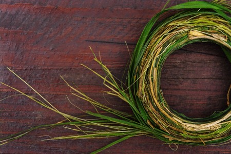 Wreath of green herbs on a brown wooden table