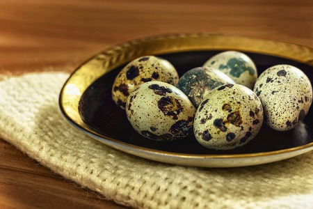 Group of quail eggs on a blue plate on a table canvas
