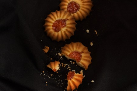 Three cookies with jam wiht crumbs in dark and moody styleの写真素材