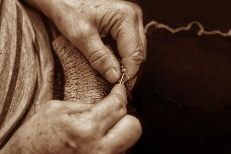 Hands with knitting needles, yarn and thread close in retro styleの写真素材