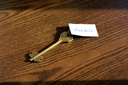 The key to freedom of bronze color on a wooden backgroundの写真素材