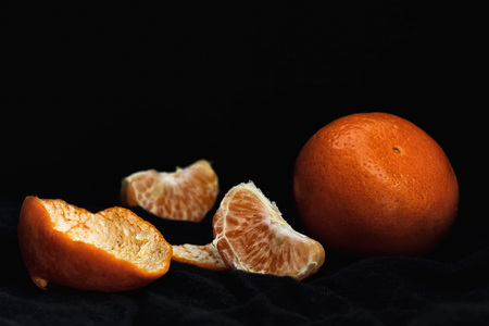 Peeled orange with slices and peel, mystical lightの写真素材