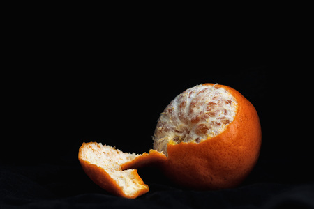 Peeled orange with slices and peel, mystical lightの写真素材