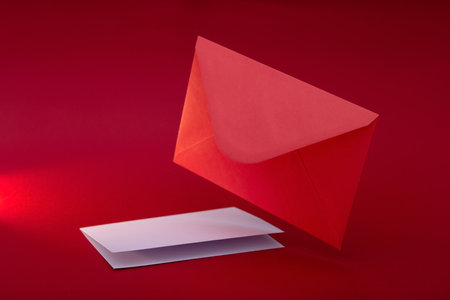 Red envelope with blank white paper. Valentine's day background. Mockup of love letter. Urgent...