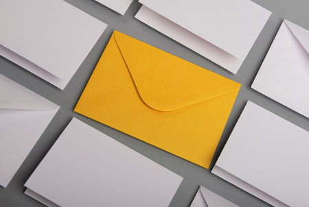 Composition with white envelopes and postcards and one yellow envelope on the table
