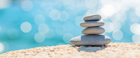Pyramid stones on the seashore on a sunny day on the blue sea background. Happy holidays. Pebble beach, calm sea, travel destination. Concept of happy vacation on the sea, meditation, spa, calmness.の写真素材