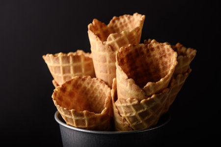 A collection of waffle cones arranged beautifully in a metal container, perfect for serving ice cream on a warm day.の写真素材