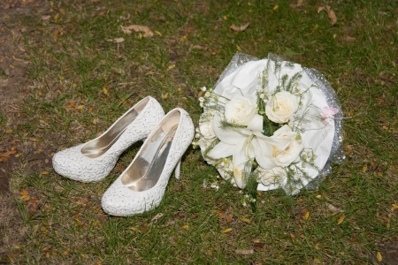 White female shoes and bouquet on the grassの写真素材
