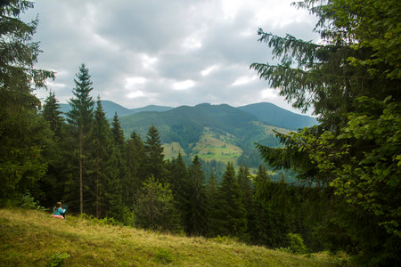 Young woman freelancer traveler working online using laptop and enjoying beautiful nature landscape...
