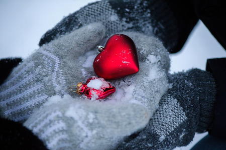lovers man and woman in mittens to keep hands, hearts and snowの写真素材