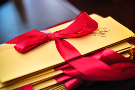 gold wedding invitation with red ribbonの写真素材