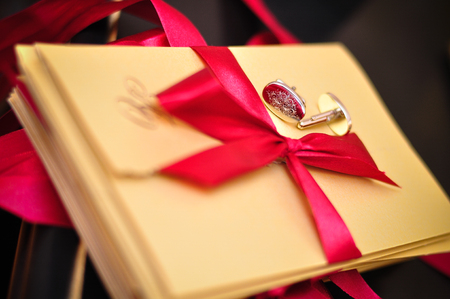 gold wedding invitation with red ribbonの写真素材