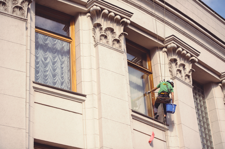 Kiev, Ukraine - June 22, 2017: man mountain climber suspended window washer in Kievのeditorial素材