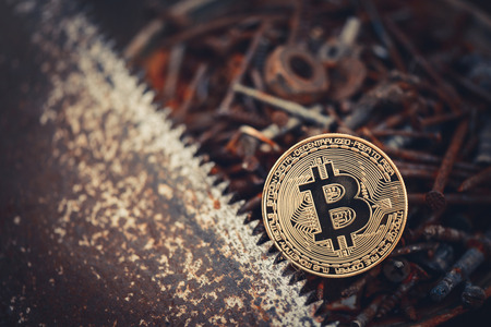 Gold bitcoin. crypto currency bitcoin against a background of rusty tools a simple working consumer. problems and business growth. warm toning.の写真素材