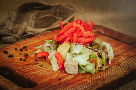 salad with turkey pepper mushrooms, cornichots and vegetables, on a wooden dostock background, beautiful serving of dishes, cozy table laying.の写真素材