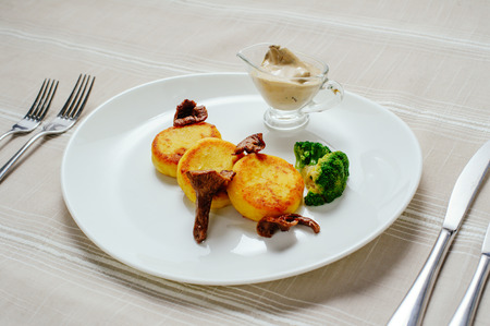 exquisite mushrooms with potatoes, potato pancakes, light table laying, cozy restaurant serve on a white background.の写真素材