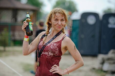 KYIV, UKRAINE - July 22, 2017: The woman the winner after overcomes a water mud barrier during power...