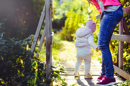  young woman with a mother on a walk, sunny bright weather, raising and caring for children.の写真素材