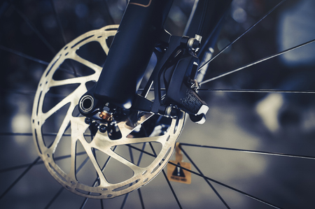 Mountain bike front wheel with mechanical disc marriage. Part of Mountain Bike brake in close up.