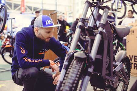 Kiev, UKRAINE - MARCH 2018:  man looks electric bike modern technology and environmental protection...