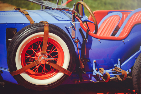 beautiful well-groomed classic retro car, stylish and luxurious, purple with red salon, spare wheel with leather straps.の写真素材