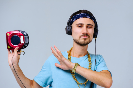 fashionable bright man in headphones in retro style manifestation of emotions of joy, gestures with hands space for text.の写真素材