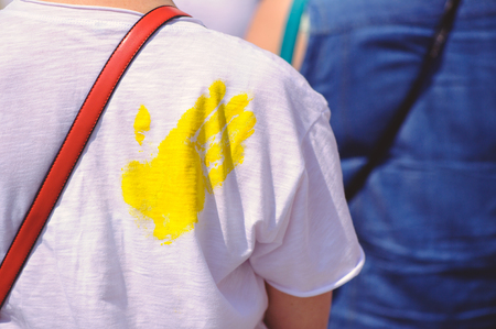 yellow palm print on a white T-shirt in a crowd of people.の写真素材