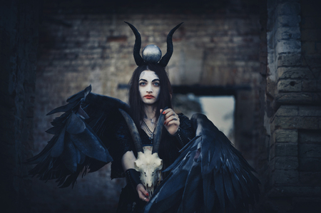 Pretty demon girl with black wings behind her backの写真素材