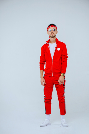 health, fun, people sport concept - happy young man wearing red sport suit on white background.の写真素材