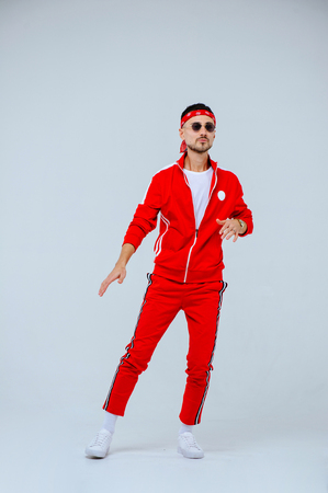 health, fun, people sport concept - happy young man wearing red sport suit on white background.