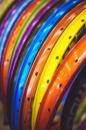 Sale beautiful colored bicycle rim stand in a row of different colors.