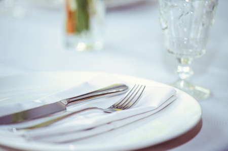 restaurant table setout with white plates and silverware.の写真素材