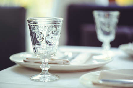 restaurant table setout with white plates and silverware.の写真素材